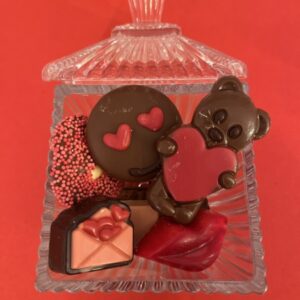 Glazen bonbonnière met diverse Valentijns chocolade.